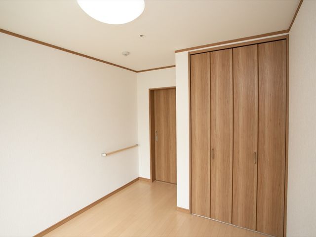 居室の入口とクローゼット 収納 落ち着いた色合いの居室は、収納スペースも広く、使い勝手と快適さを考慮した設計になっています。