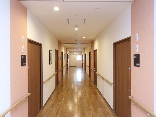 清潔な廊下 通路  手すりが設けられた明るく広々とした廊下です。スタッフの方々の行き来もスムーズです。