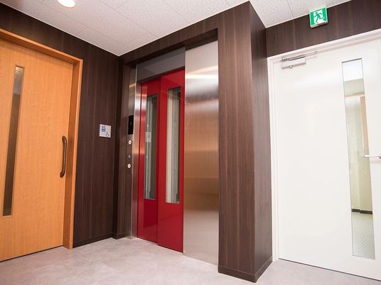 赤いエレベーターと廊下の扉