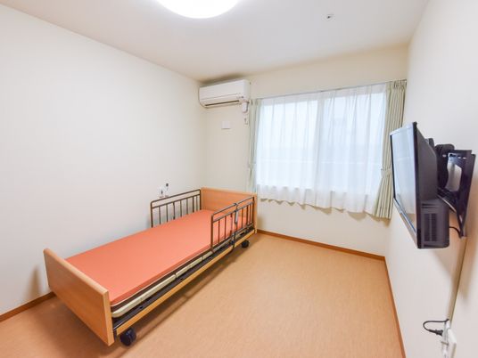明るい居室のベッドとテレビ