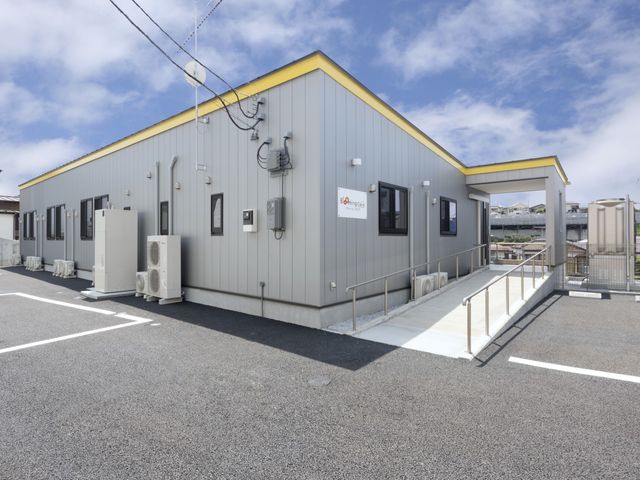 スロープ付きの建物外観 外観 広い駐車スペースとスロープがあり、通勤や来訪がしやすいです。モダンなデザインが特徴的です。