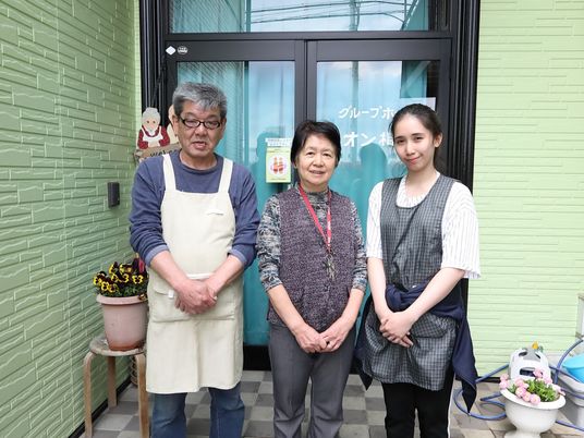 笑顔のスタッフ三人とエントランス