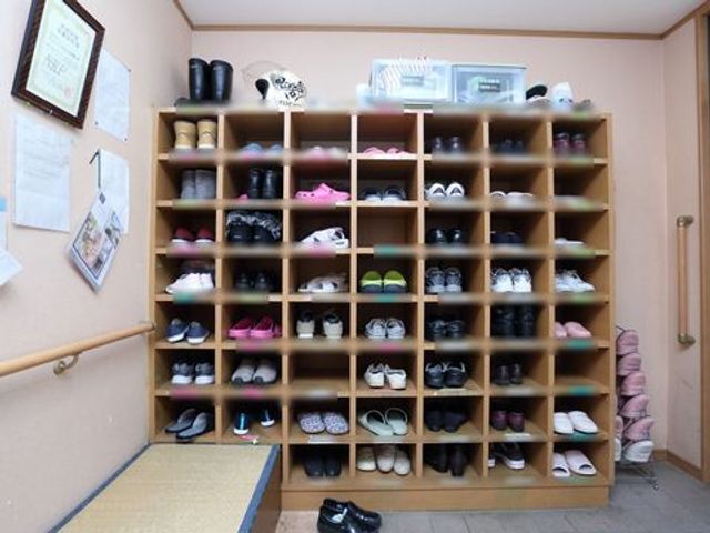 玄関の靴棚 靴箱 ゆとりある玄関で、靴の収納も整然と管理されており、訪れる人々を暖かくお迎えいたします。手すりも設置され、安心してご利用いただけます。