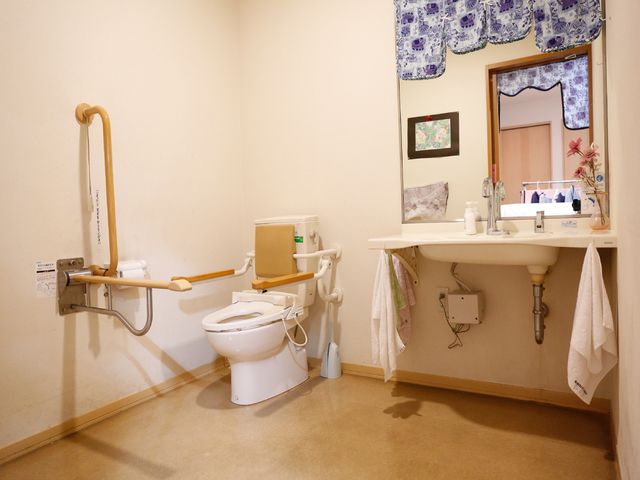 バリアフリートイレ トイレ 壁に手すりが設置された清潔なトイレ空間です。安全と利便性を考え抜かれた設計になっており、すべての方が安心してご利用いただけます。