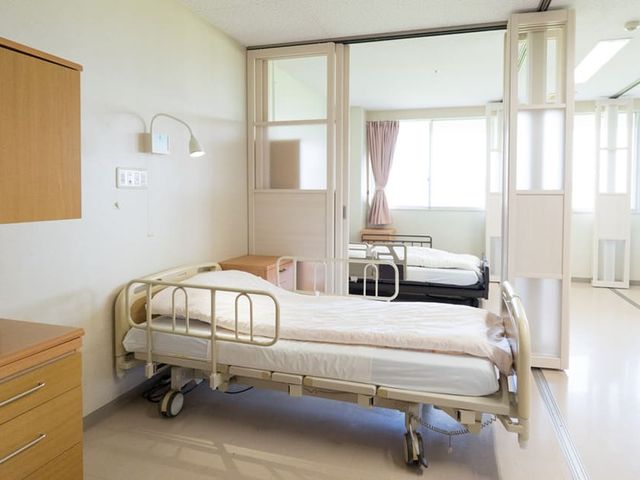 窓際に設置されたベッドがある居室 居室   自然光が心地良い居室です。ベッドは窓際に配置され、明るく快適に過ごせます。
