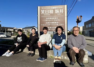 看板前で微笑む人々