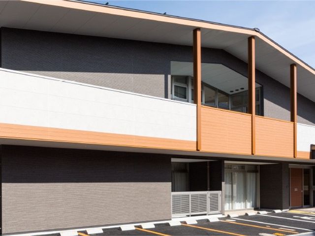 モダンな建物外観 外観   木目調のアクセントが映える、落ち着いた印象の建物です。駐車スペースも見えて、来訪しやすい雰囲気があります。