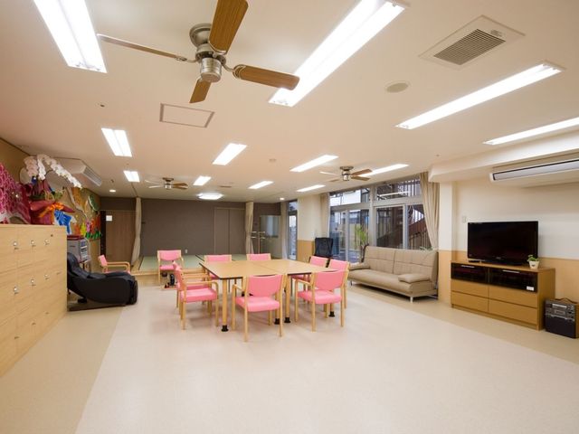 明るい共有リビング リビング 自然光が入りやすい広い空間に、テレビやソファ、テーブル席が整っています。利用者さんが集まりやすく、見守りもしやすい環境です。
