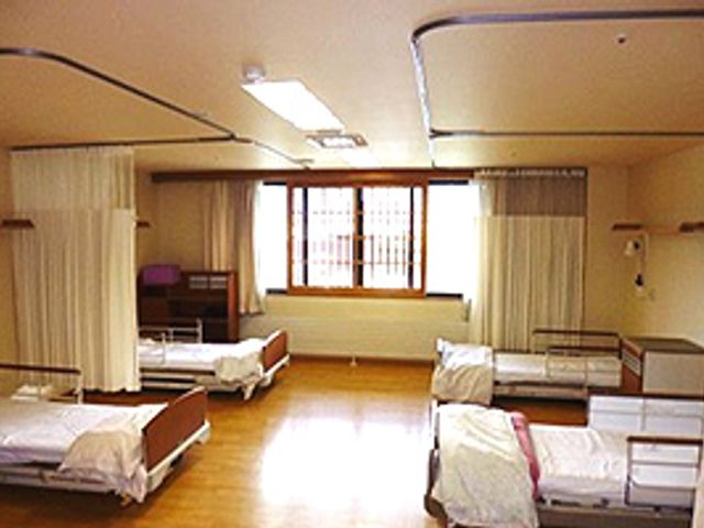 ベッドが並ぶ空間 居室 自然光が入り込み、温かみを感じられる居室です。ベッド間には仕切りがあり、プライバシーを確保しています。