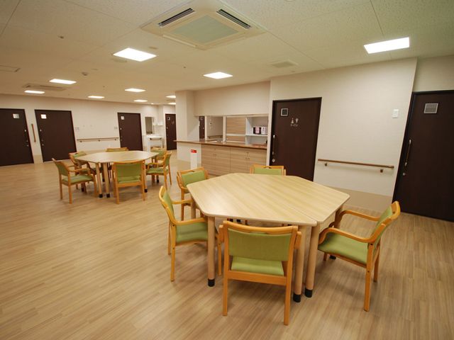 木製テーブルと椅子の部屋 食堂 明るく広々とした空間で、落ち着いた食事の時間をお過ごしいただけます。車椅子の方もご利用しやすい設計です。