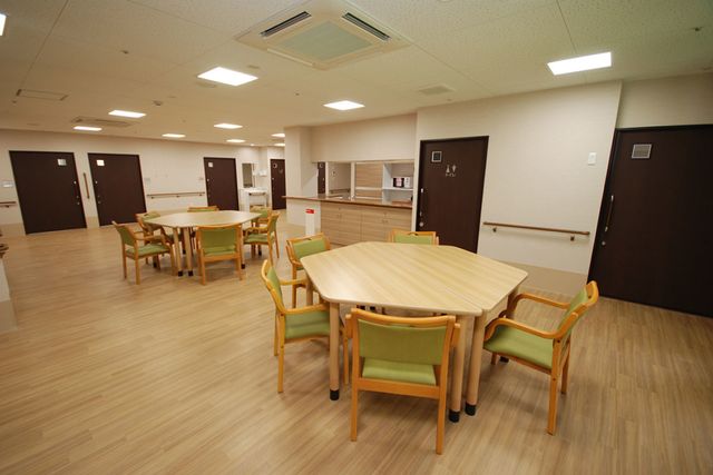 木製テーブルと椅子の部屋 食堂 明るく広々とした空間で、落ち着いた食事の時間をお過ごしいただけます。車椅子の方もご利用しやすい設計です。