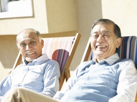 笑顔で椅子に座る高齢者二人