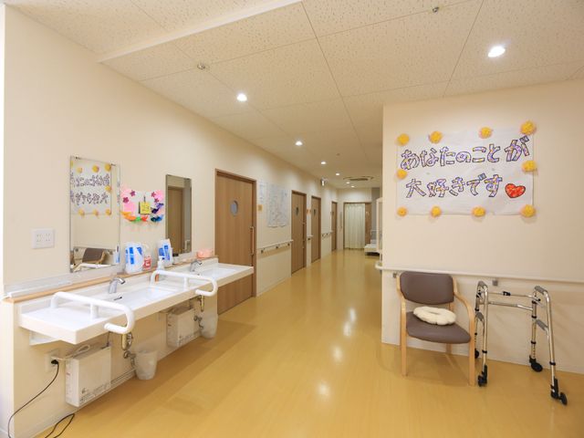 明るい廊下と掲示物 リビング 手すりと広々とした通路があり、壁には季節感ある飾りが施されております。こだわりが感じられる心温まる空間です。