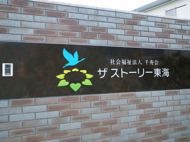 施設看板の外壁 看板   レンガ調の壁に、施設名が見やすく掲示されています。入口を探す際の目印になりそうです。
