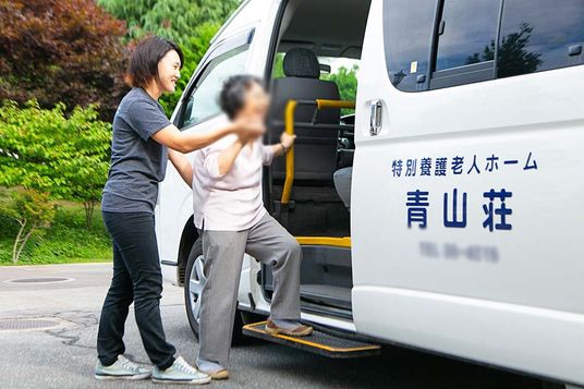 送迎車から降りる場面