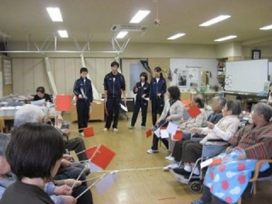 旗を振る人々がいる機能訓練室
