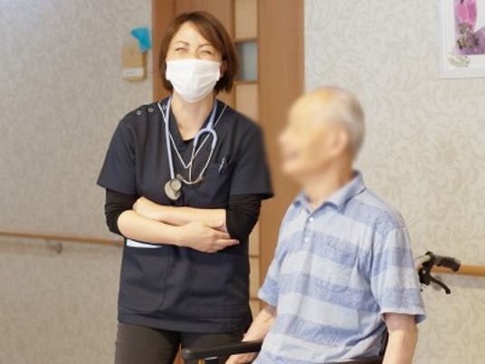 車椅子の方とスタッフがいる廊下
