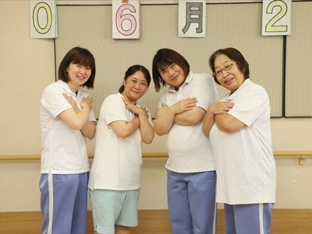 笑顔のスタッフたちの様子 スタッフイメージ 和やかな雰囲気の中でスタッフが笑顔を見せています。チームワークを感じる職場環境です。