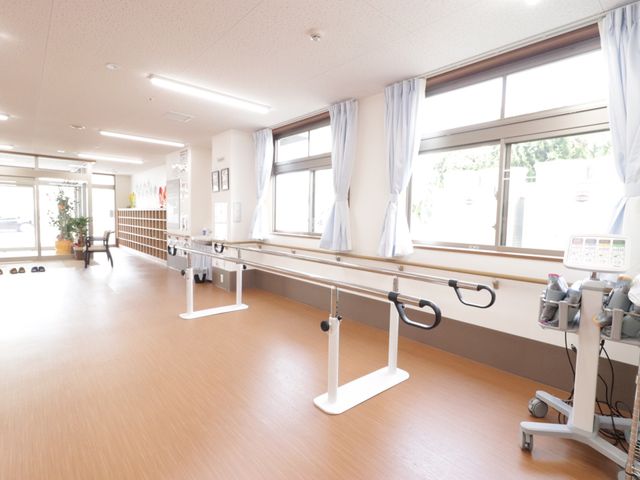 広々とした機能訓練室 ホール 光が差し込む清潔な機能訓練室です。利用者の皆さんの身体機能向上をサポートするための設備が整っています。