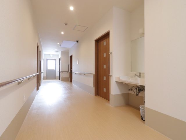 清潔感のある明るい廊下 廊下 清潔でゆったりとした廊下が、心地よい移動空間を提供しています。床には手すりが備わり、安全に配慮された設計となっています。