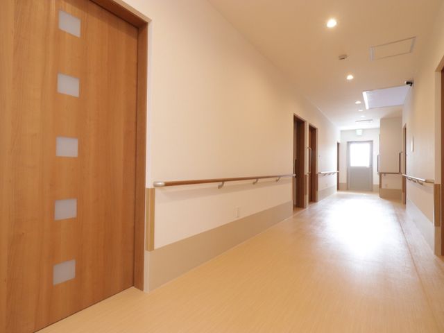 明るい廊下 廊下 手すりが備えられた温かみのある通路です。清潔感のあふれる空間が、働く環境の良さを物語っています。