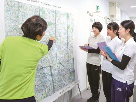スタッフが地図を確認する廊下  