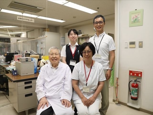笑顔のスタッフと利用者の室内 内観 明るい室内で、スタッフと利用者が笑顔でいます。働きやすい雰囲気を感じる空間です。