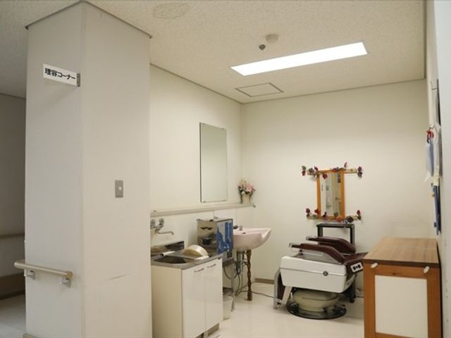理美容コーナーのある部屋 理美容室   明るい空間に洗面台や鏡、理美容用の椅子が整っています。身だしなみを整えやすい、落ち着いた雰囲気です。