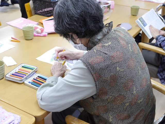 塗り絵をする様子の多目的室 多目的室 落ち着いた雰囲気の中で、利用者の方が塗り絵を楽しめるスペースです。机周りにはカラフルな画材が揃っています。