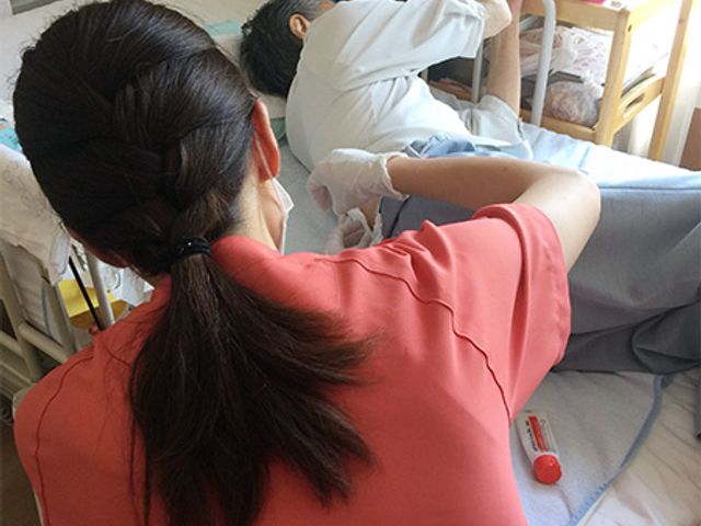 ケア中のスタッフと利用者の居室 居室 スタッフが利用者のケアを行っている様子です。和やかな雰囲気の中、安心して働けます。