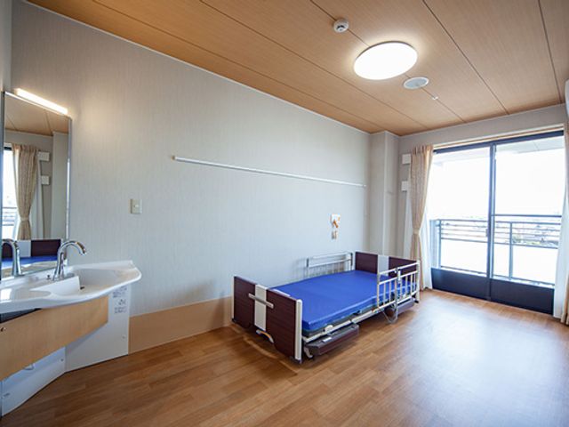 リラックスできる居室 居室 窓から自然光が差し込む明るい空間です。快適なベッドと洗面台も備えています。