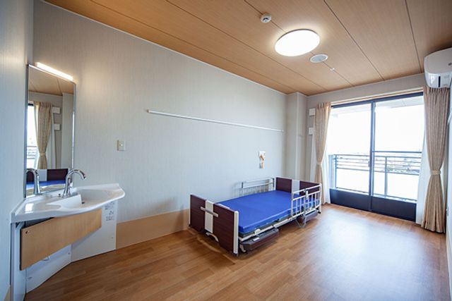 リラックスできる居室 居室 窓から自然光が差し込む明るい空間です。快適なベッドと洗面台も備えています。