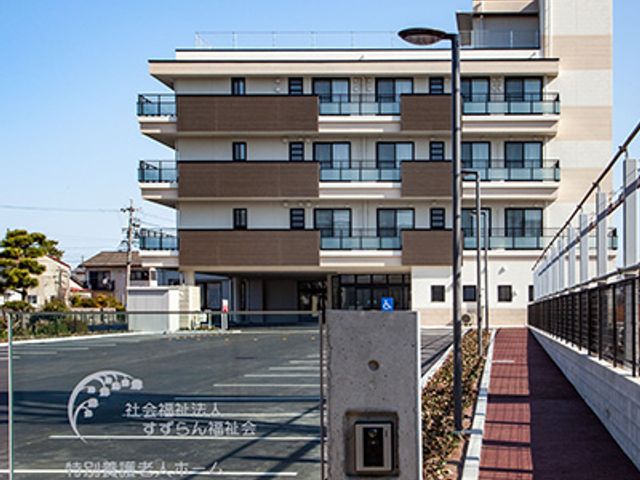 白い外壁の四階建て建物外観 外観 この建物は近代的で、広々とした駐車スペースがあります。車利用でも通勤しやすいです。