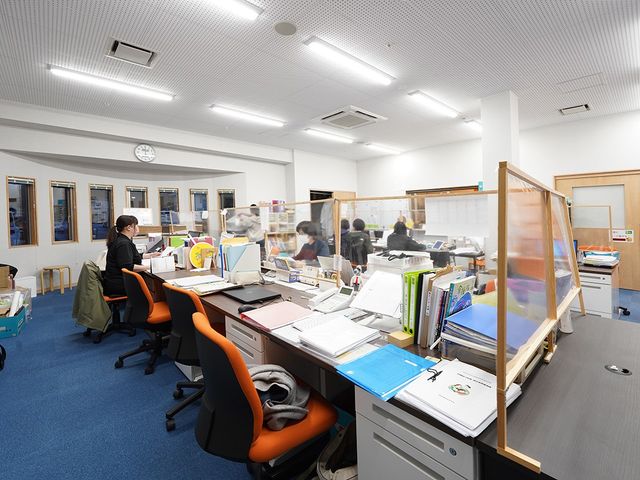快適なオフィス空間 スタッフイメージ 開放的な環境で集中して働けます。スタッフがやり取りを行っている様子が伺えます。