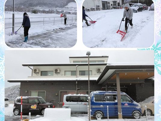 雪かきする施設前の外観  