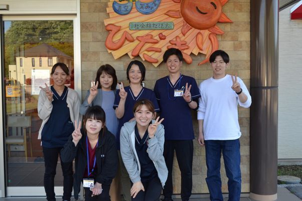 笑顔のスタッフと看板