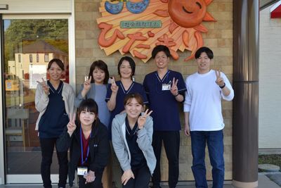 笑顔のスタッフと看板