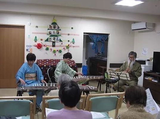 楽器演奏を聴く高齢者たち