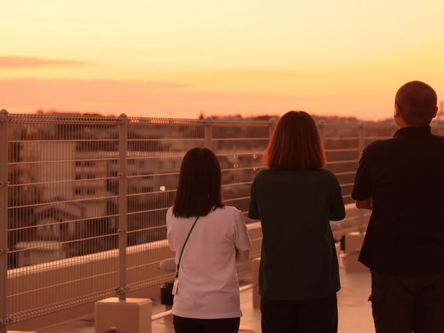 夕日を眺める人々 バルコニー 夕日をバックに、皆がバルコニーでリラックスしています。自然と触れ合うことができる空間です。