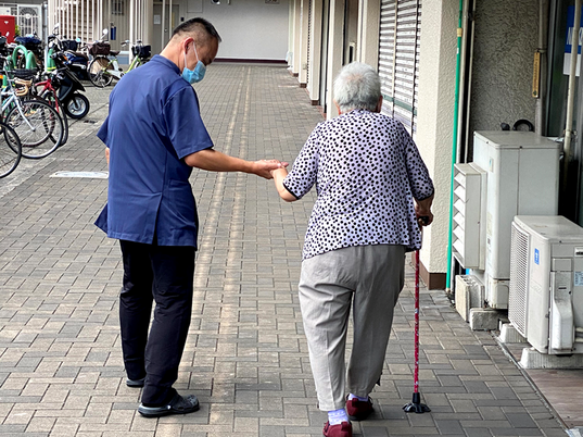 親切なスタッフと入居者、廊下  