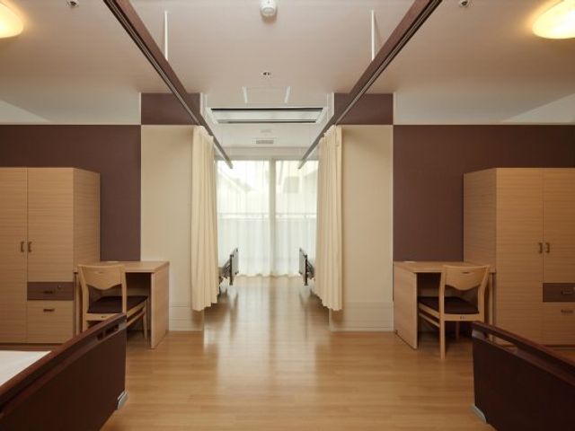 落ち着いた色合いの居室 居室 落ち着いた色合いの居室です。一人ひとりのスペースがしっかりと区切られており、プライバシーを確保しています。