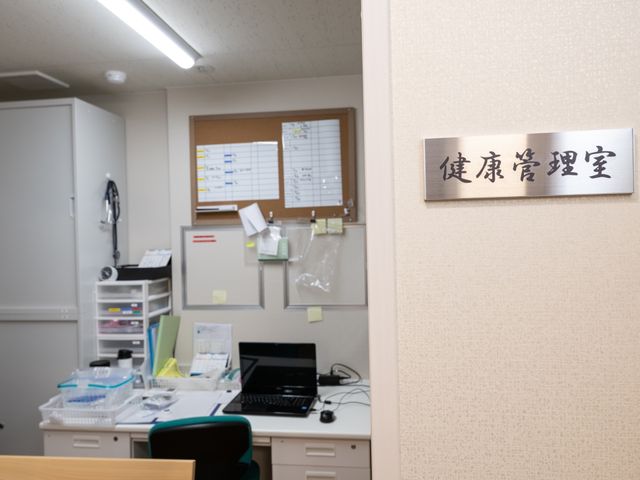 健康管理室内部 健康管理室 清潔に整えられた健康管理室です。必要な医療機器や資材が整然と配置され、快適な職場環境が整っています。
