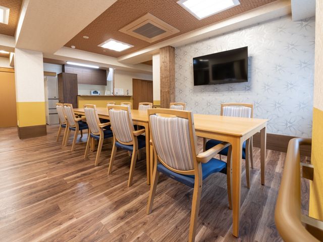 明るいダイニングルーム 共有スペース ゆとりある配置のダイニングテーブルが特徴で、共に食事や会話を楽しむ場として最適です。清潔感のあふれるこの空間で、日々のコミュニケーションが図られています。