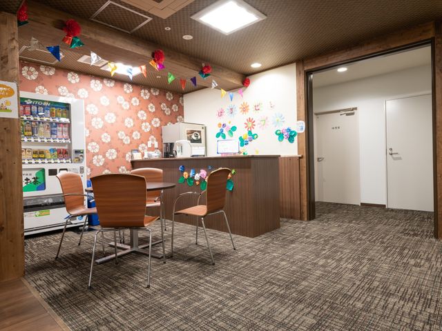 休憩スペースの多彩な装飾 休憩コーナー カラフルな飾り付けが施された居心地の良い休憩スペースです。自動販売機やドリンクサーバーも完備され、ちょっと一息つくのに最適です。