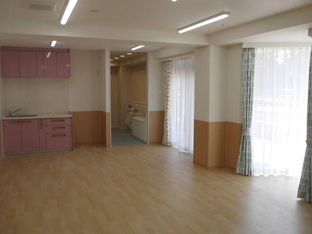 明るいリビング リビング   広い床面が見える明るい共有スペースです。窓から自然光が入り、くつろぎやすい雰囲気になっています。