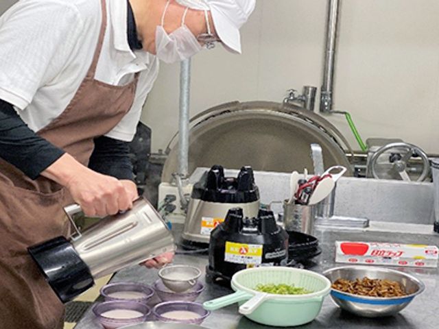 調理風景のキッチン キッチン 職員が真剣に献立を準備する様子です。清潔な環境が整い、安心して調理が行える設備です。