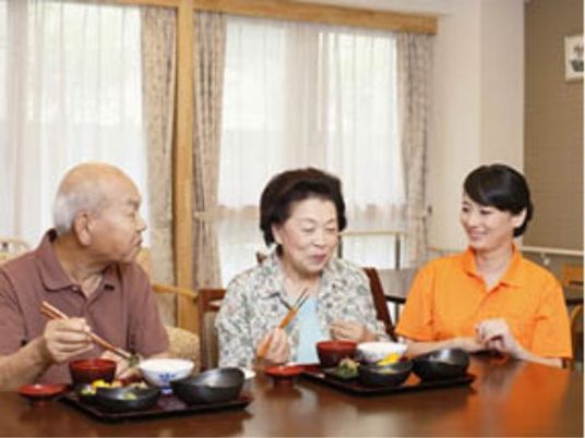 食事をとる人々とスタッフ