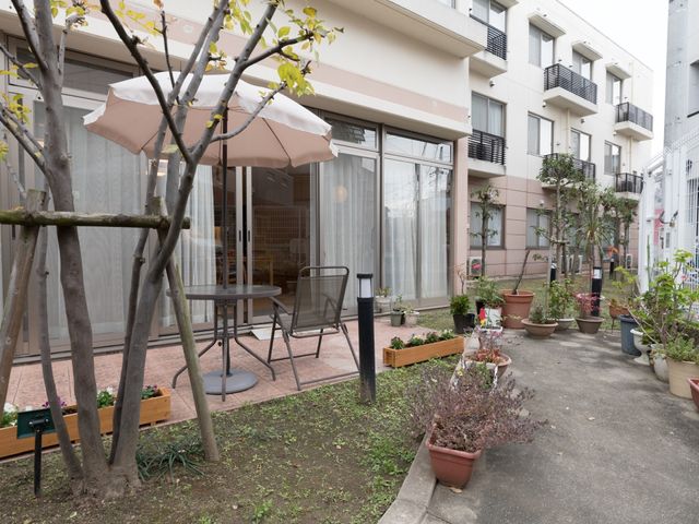 屋外休憩スペースとテーブル 中庭 手入れされた中庭には、植物を眺めながら一息つけるテーブルと椅子があります。新緑が心地よい、くつろぎの時間を提供しています。