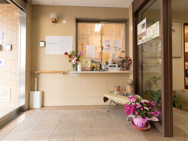 エントランスに花と掲示物 風除室 温かみのあるエントランスは、訪れる人に明るい印象を与えます。掲示物で日々の情報共有が行われています。