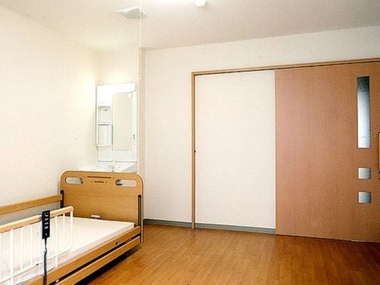 フローリングの居室には洗面所や介護用ベッドが置かれている。